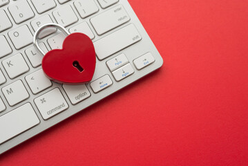 Love red heart shape lock and white keyboard on red background with copy space. Find love, romantic, dating in online internet website, app dating community platform concept. Quick and easy.