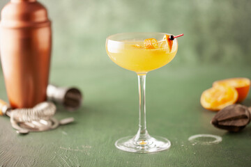 Boozy Corpse Reviver No 2 Cocktail with Gin and Lemon in Cocktail glass. Alcoholic drink and bar tools.