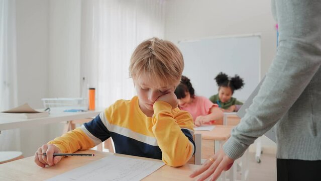 Young primary student stress while examination and feeling worried about having problems learn in classroom at elementary school.Learn and education concept.