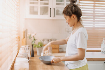 Obraz na płótnie Canvas Asian woman preparing breakfast in the kitchen in the morning.
