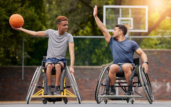 Sports, basketball and men in wheelchair on court for training, exercise and workout on outdoor park. Fitness, team and male people with disability play with ball for competition, practice and games