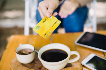 Young woman paying for cafe by credit card