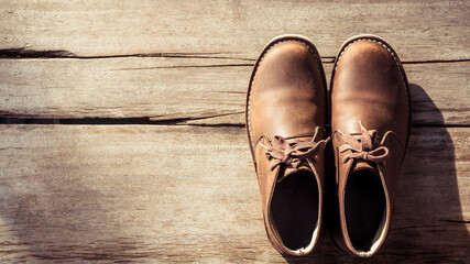 Brown stylish boots on wood background,  retro color