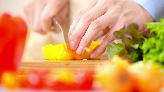 パプリカを切る若い男性　料理イメージ