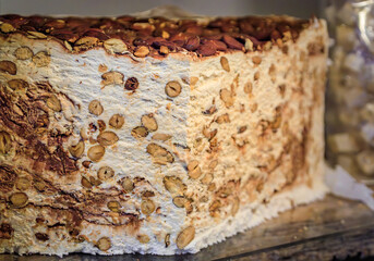 Block of fresh classic white nougat with almonds, hazelnut and honey at an artisanal candy shop in the medieval town of Saint Paul de Vence, France