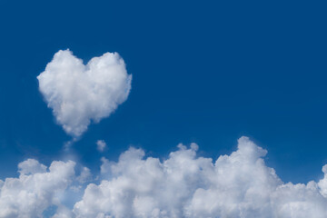 Group of white fluffy clouds on fresh blue sky with one softy cloud shaping like a heart. Background with copy space for lovely content or meteorology presentation or natural and environment concept. - obrazy, fototapety, plakaty