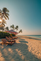 Beautiful tropical sunset coast, two sun beds, loungers, umbrella under palm trees. Closeup sand, sea horizon, colorful twilight sky, calm and relax. Peaceful romantic couple travel vacation landscape