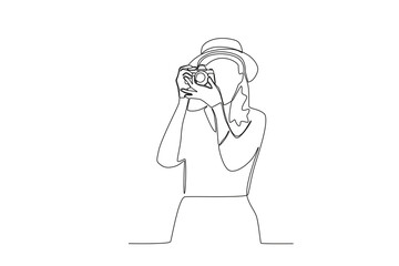 One continuous line drawing of a female photographer taking a photo from the front
