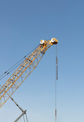 Construction crane on blue sky background