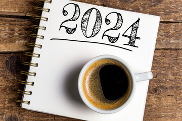 Obraz na płótnie Canvas New year resolutions 2024 on desk. 2024 resolutions list with notebook, coffee cup on table. Goals, resolutions, plan, action, checklist concept. New Year 2024 template, copy space