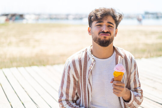 Handsome Arab Man With A Cornet Ice Cream At Outdoors With Sad Expression