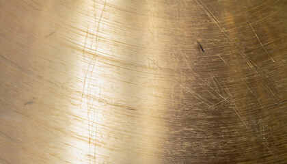 Brushed brass plate background texture, metal surface with scratches and dents, selective focus