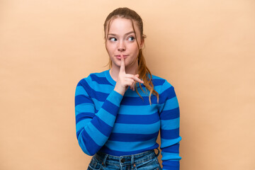 Young caucasian woman isolated on beige background showing a sign of silence gesture putting finger...