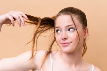 Young caucasian girl isolated on beige background with tangled hair. Close up portrait