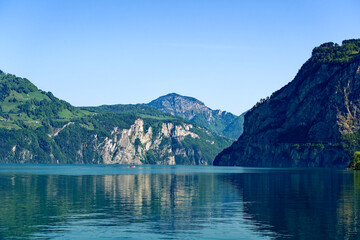 Scenic view of mountain panorama at Lake Lucerne with Swiss village of Seelisberg on top of mountain on a sunny spring day. Photo taken May 22nd, 2023, Sisikon. Switzerland.