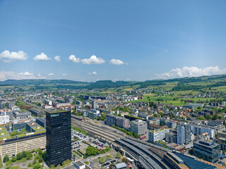 Aerial view of Swiss City of Zug with railway station and black skyscraper on a sunny spring day. Photo taken May 22nd, 2023, Zug, Switzerland.