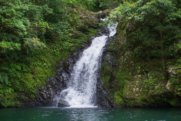 エメラルドグリーンの滝つぼに勢いよく流れ落ちるマテリヤの滝