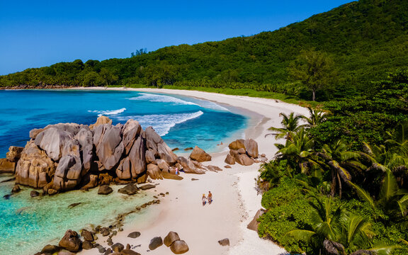 Anse Cocos La Digue Seychelles, a young couple of men and women on a tropical beach during a luxury vacation in Seychelles. Tropical beach Anse Cocos La Digue Seychelles with a blue ocean © Fokke Baarssen