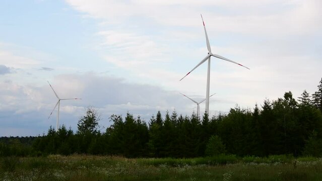 Wind turbines spinning in the wind during a sunset in the Black Forest