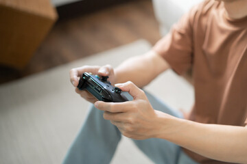 Young Asian man gamer controller video console playing holding hobby playful Online Video Game enjoyment eSport Cyber Games Internet. © Charlie's