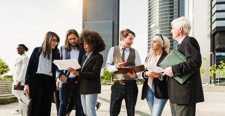 Business people discussing about fin tech project after work - Multiracial colleagues doing financial strategies outside of the office - Teamwork and startup concept - Main focus on center man face