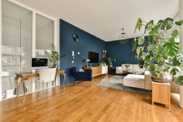 a living room with wood floors and blue walls, white furniture and a large plant in the center of...