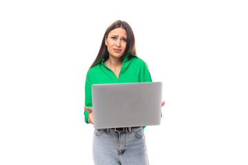 portrait of a happy slim cute brown-eyed brunette woman dressed in a green shirt working using a laptop. online work concept