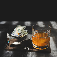 Alcohol drink in a glass, syringe with a dose of drugs, white pills, narcotics powder, US dollar currency cash on dark background. Concept of addiction, abuse and bad habits