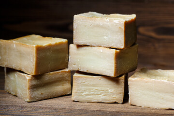 Bars of traditional aleppo natural laurel soap on a wooden background.