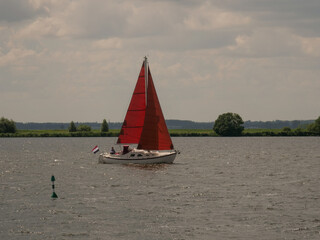 Sailing boat with red sail at lake Eemmeer in the Netherlands