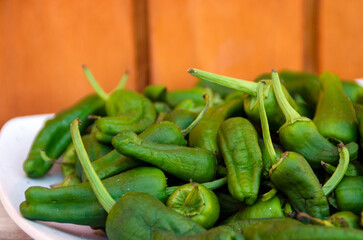 Pimientos verdes sobre un plato en un fondo de madera