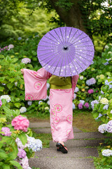 Back view of a woman wearing a Japanese bathrobe Yukata and holding a Japanese traditional oil...