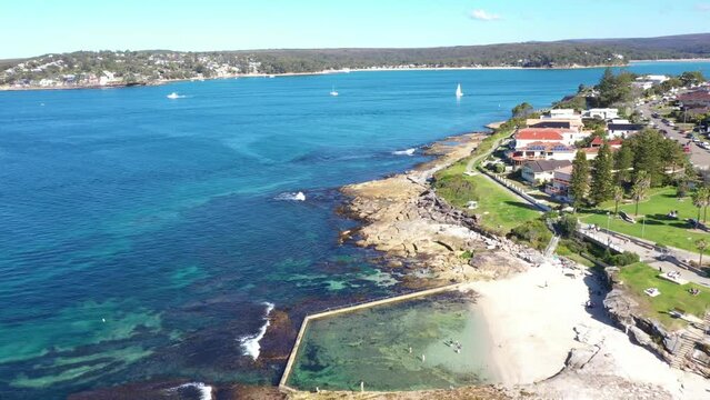 Aerial drone view of Cronulla South along Oak Park Beach and Rock Pool in the Sutherland Shire, South Sydney, NSW Australia looking south over Port Hacking on a sunny day in July 2023  