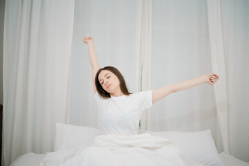 Fototapeta na wymiar Image of beautiful woman resting in white bed at bedroom. in morning . Lifestyle at home concept..