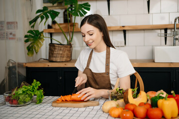 young woman with cutting board of cut lettuce at kitchen. healthy food concept.