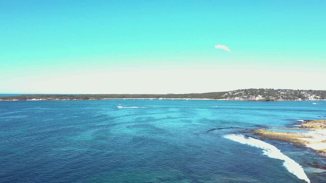 Aerial drone view rising up over Cronulla South along Oak Park Beach and Rock Pool in the Sutherland Shire, Sydney, NSW Australia looking south over Port Hacking on a sunny day in July 2023  