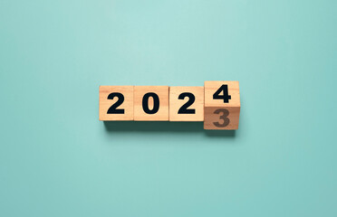 Flipping of 2023 to 2024 on wooden block cube for preparation new year change and start new...