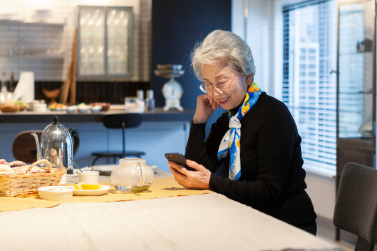 カフェでスマートフォンを操作するシニア女性