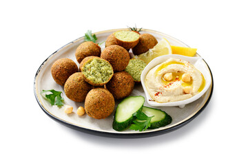 Plate of chickpeas falafel balls with hummus, vegetables  and lemon slices. isolated on white...