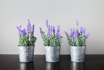 Three small tin buckets filled with artificial lavender.