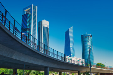 Elevated road with the skyscrapers of the Cuatro Torres Business area in Madrid in the background - obrazy, fototapety, plakaty