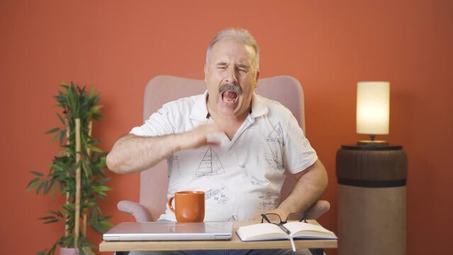 The old man's mouth is burning from the hot drink.