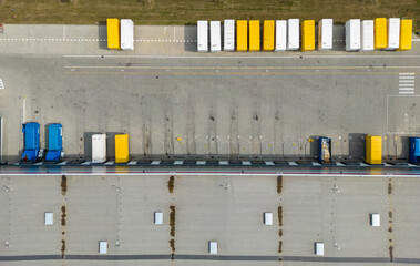 aerial drone view of  warehouse building with bays and trucks

