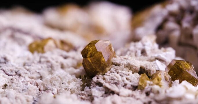 vesuvianite crystal with moving light in 4k. macro detail texture background. close-up raw rough unpolished semi-precious gemstone