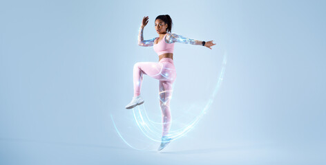 Young black woman in sportswear jogging, jumping on blue background