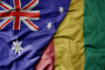 big waving realistic national colorful flag of australia and national flag of guinea .