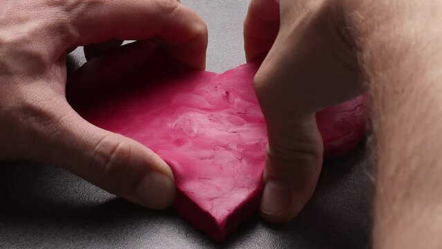 A man tears his heart in half. The concept of shattered love, betrayal, human indifference and cruelty. 