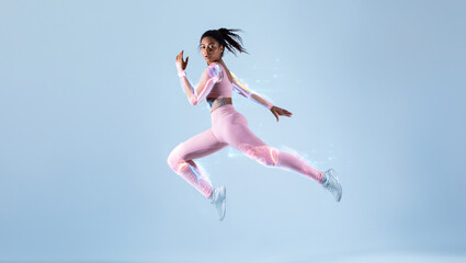 Obraz na płótnie Canvas Futuristic training concept. Fit black woman in sportswear jumping, running