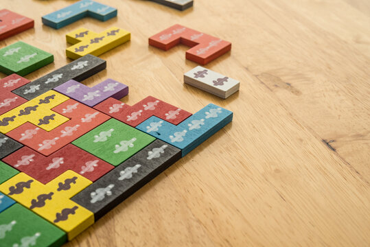 Wooden puzzle block game with dollar symbol on wooden background. Money game competition, business strategy, money management planning, problem solving, investment trading tactic concept