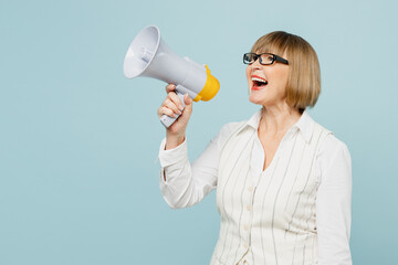 Employee business woman 50s wear white classic suit glasses formal clothes hold megaphone scream announces discounts sale Hurry up isolated on plain pastel blue background. Achievement career concept.